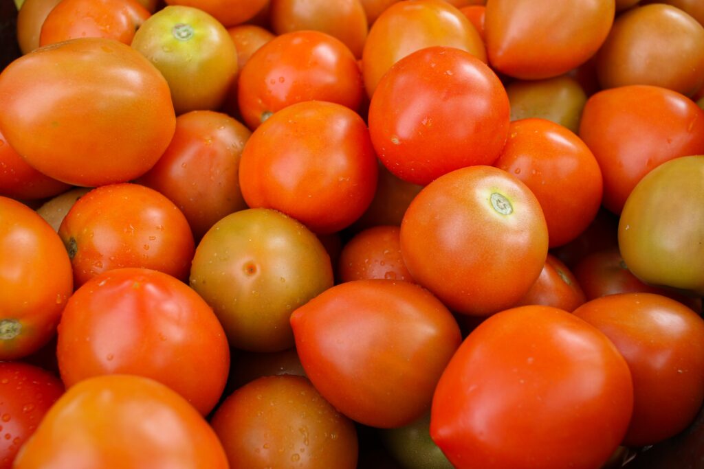 Close-up of ripe red tomatoes with water droplets showcasing freshness at a market display.